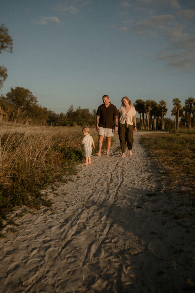Family walking through by sea grass during a storytelling family session in Tampa Bay