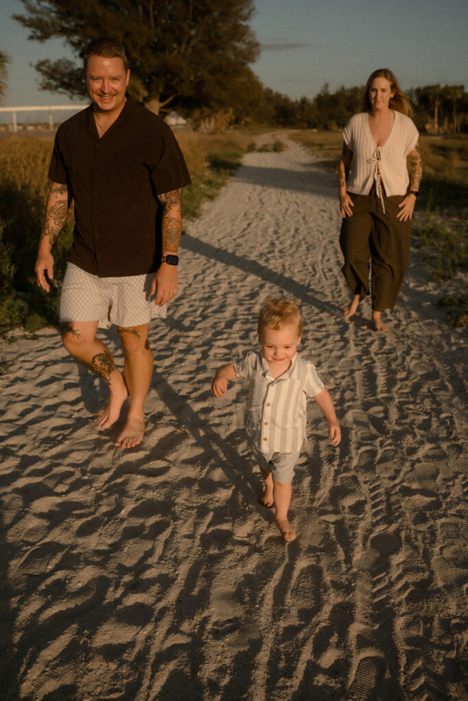 Family walking through by sea grass during a storytelling family session in Tampa Bay