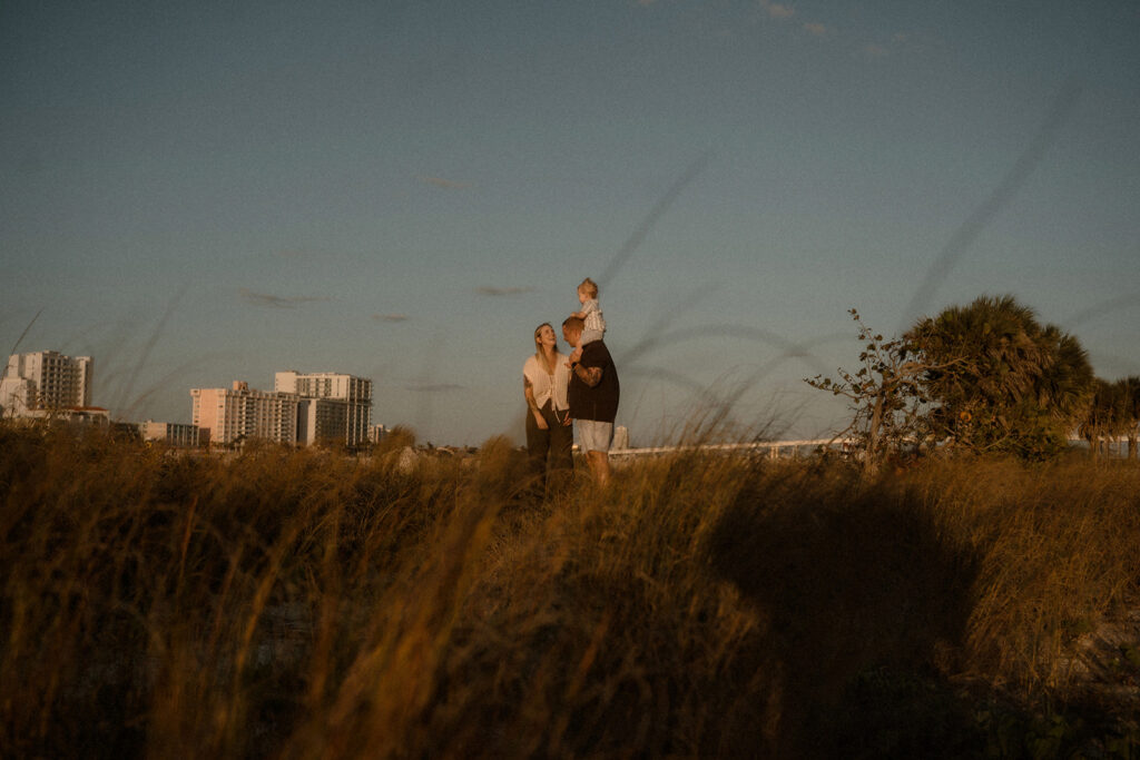 Family walking through by sea grass during a storytelling family session in Tampa Bay