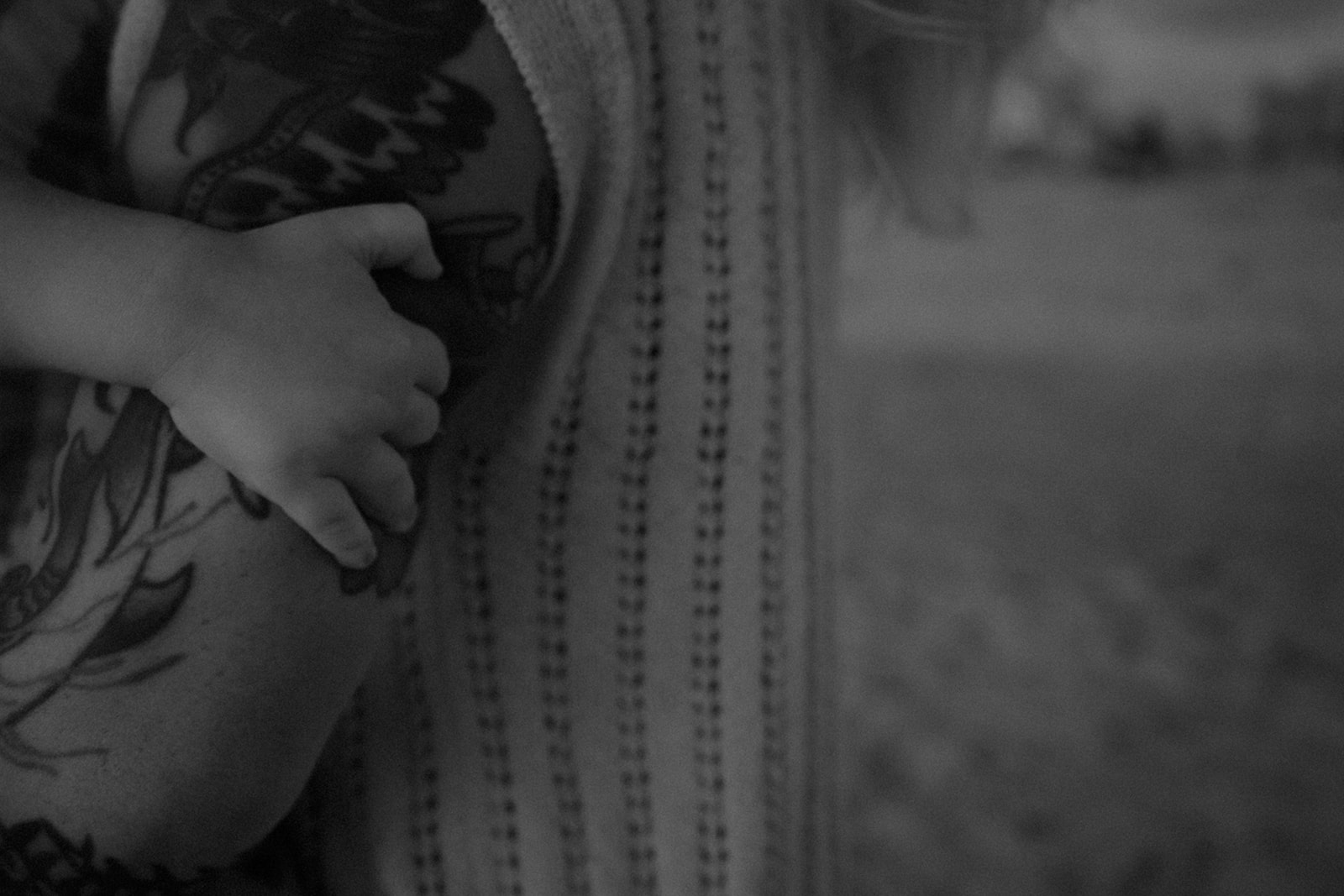 Black and white close-up of a child holding his mother’s arm during a storytelling family session in Tampa Bay